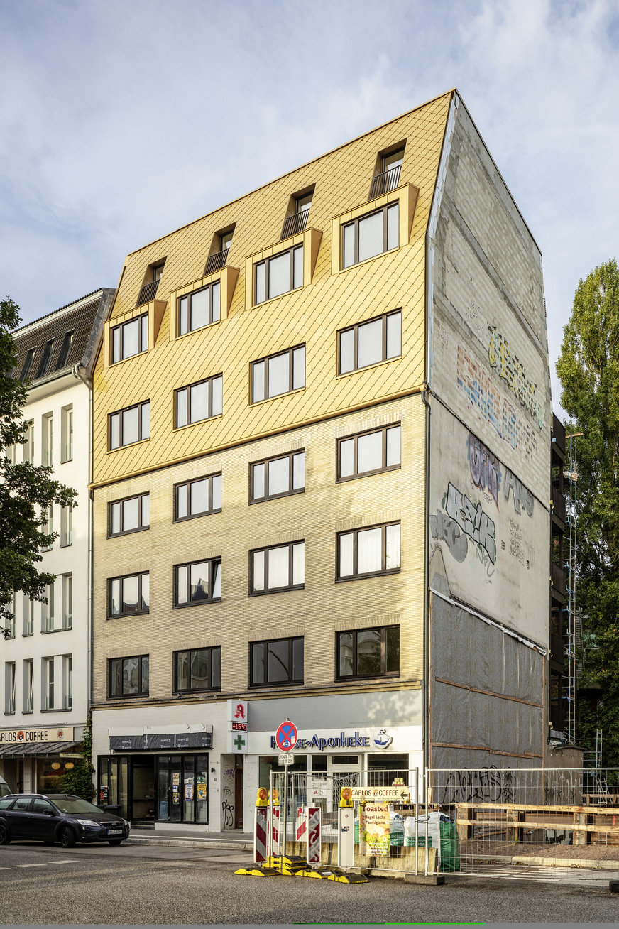 Ton in Ton: Die stehfalzbekleideten Gauben haben die gleiche Farbe wie die Fassade. Ein dezenter Knick dient als Traufkante