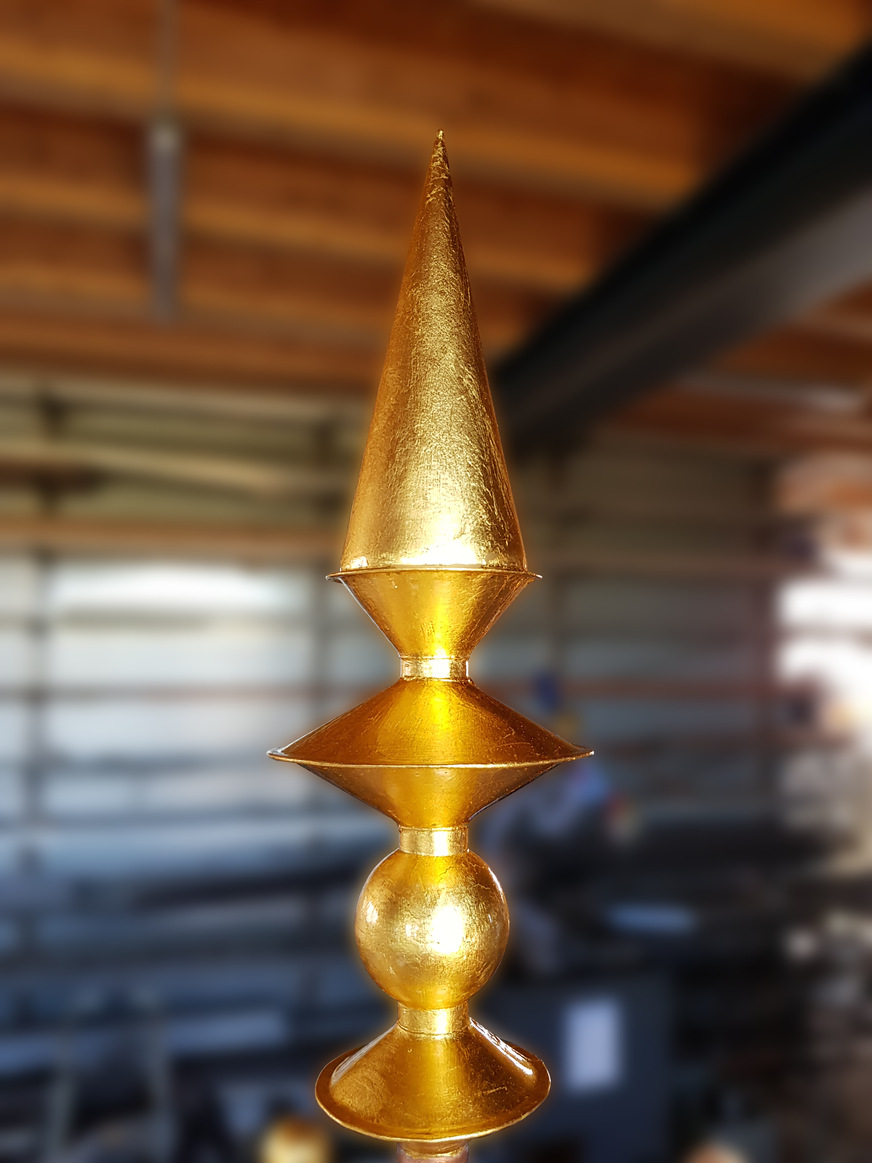Die aus 4 unterschiedlichen Körpern bestehende Spitze der Bekrönung wurde mit einer glänzenden Goldschicht überzogen