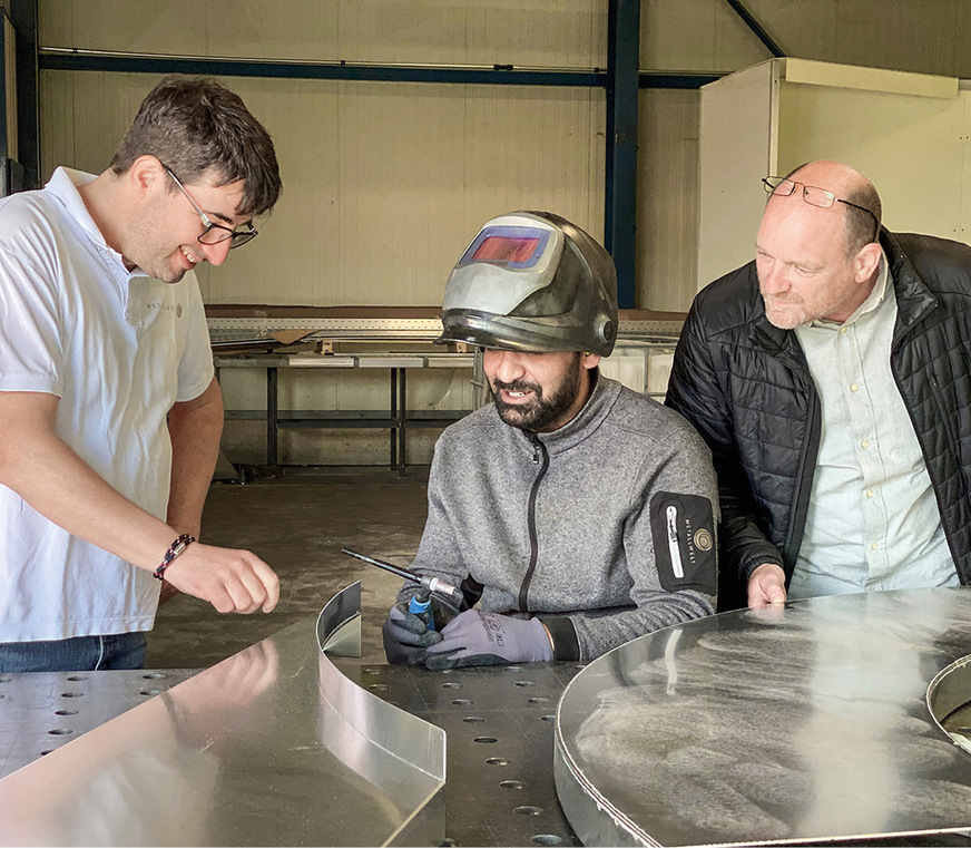 Christoph Rüschenbaum, Arsim Coljaj und Ralf Senger von Metallwelt begutachten gerundete Profile