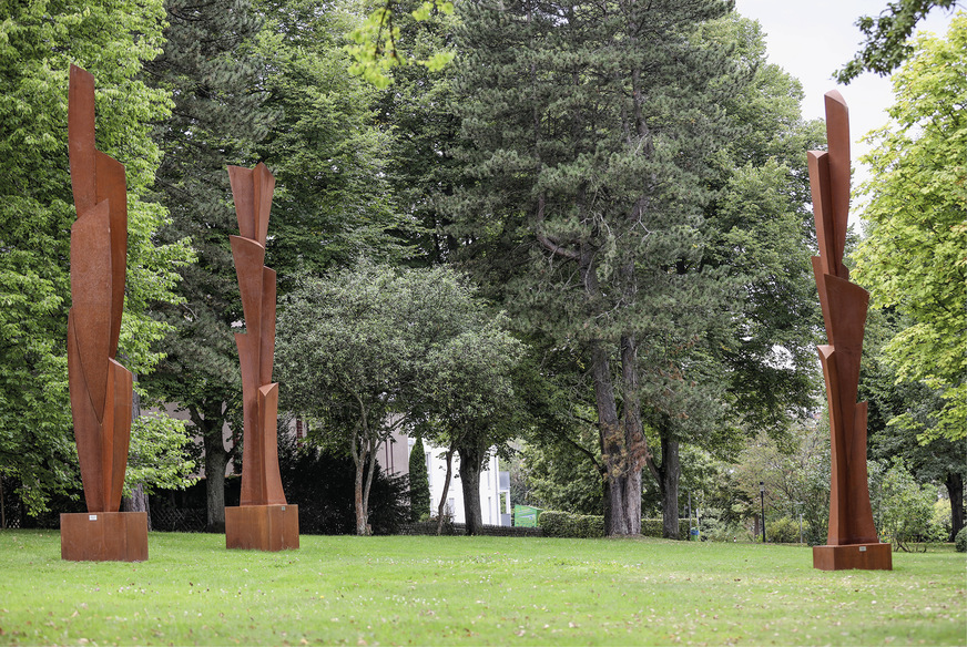 Formvollendet wachsen die Cortenstahl-Bäume „Arbre“ in die Höhe,