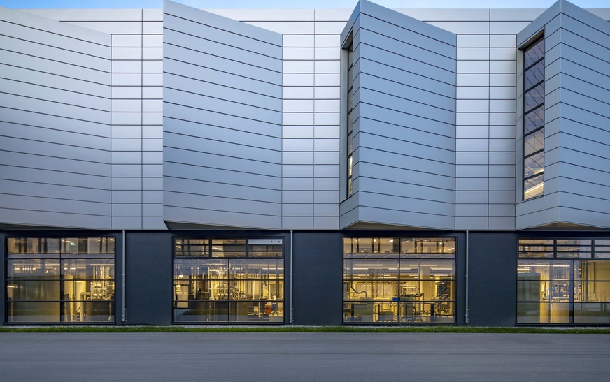 Raumhohe Fenster und die seitlich angeordneten Gebäudekiemen der Produktionshalle sichern höchste Tageslichtnutzung und damit eine angenehme Arbeitsatmosphäre.