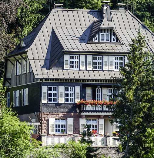 Ein Dach mit großen Vorsprüngen und heruntergezogenen Walm- bzw. Krüppelwalmdachflächen