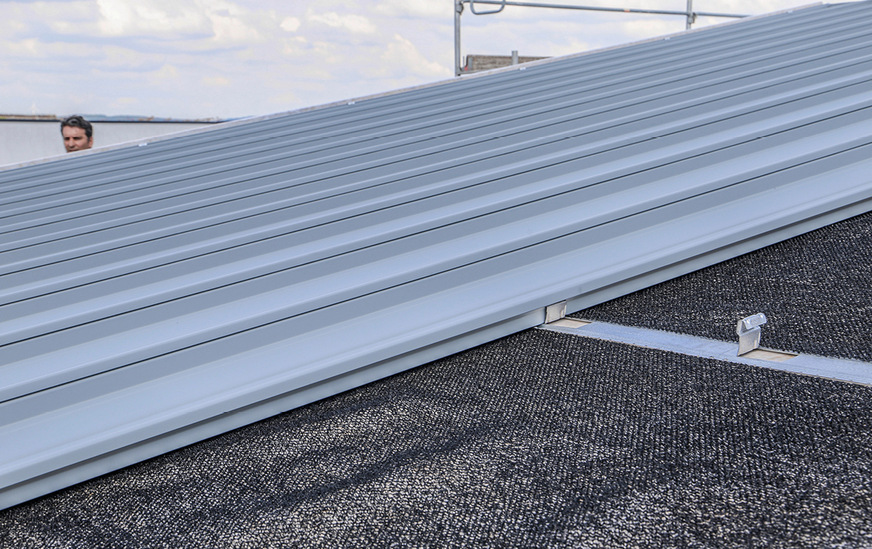 Optimaler Lärmschutz: Das Rib-Roof Akustikdach reduziert den Regenschall um ca. 6 Dezibel. Es verfügt über eine unterseitig aufgewalzte, 3 mm starke Akustikvlieskaschierung sowie ein Wirrgelege als weitere Zwischenlage