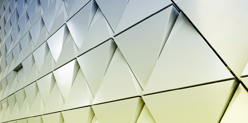 Nahaufnahme einer modernen, hinterlüfteten Aluminiumfassade aus Dreiecken