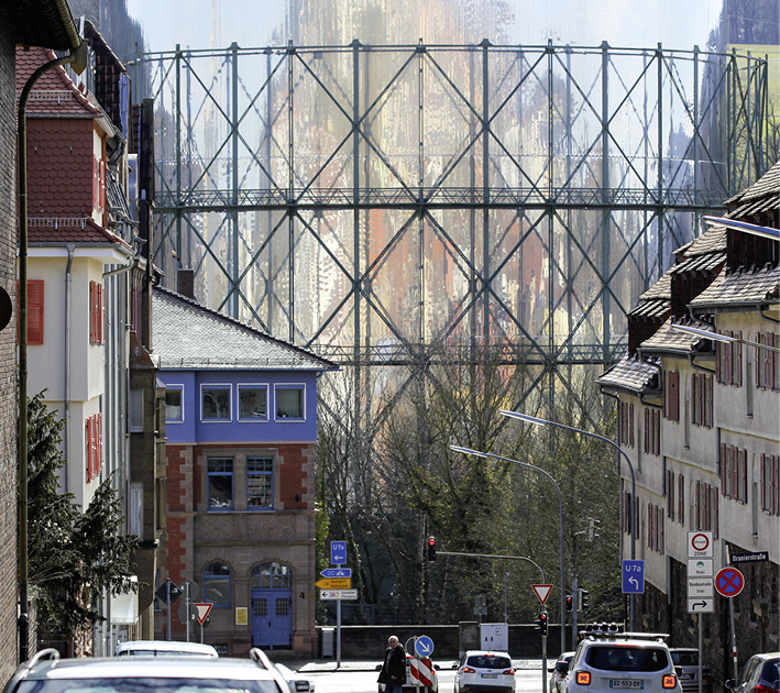 Ein gigantischer Gasbehälter mit einer Fassade aus poliertem Edelstahl, in der sich das Umfeld spiegelt