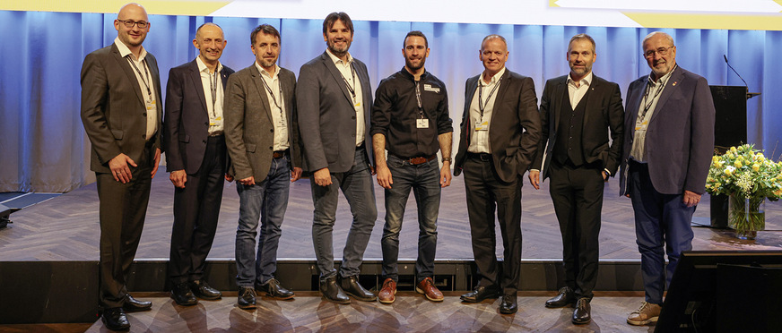 Gemeinsam bilden die Verbandsvertreter Michael Kober (D, ZVSHK), Ulrich Leib (D, ZVSHK), Roman Josef Moosbrugger (A, WKO), Alexander Eppler (A, WKO), Florian Schnyder (CH, Suissetec), Claudio Christina (CH, Suissetec), Remo Wyss (CH, Suissetec) und Hubert Trenkwalder (I, Südtiroler Spengler Innung) die Dachs-Gruppe