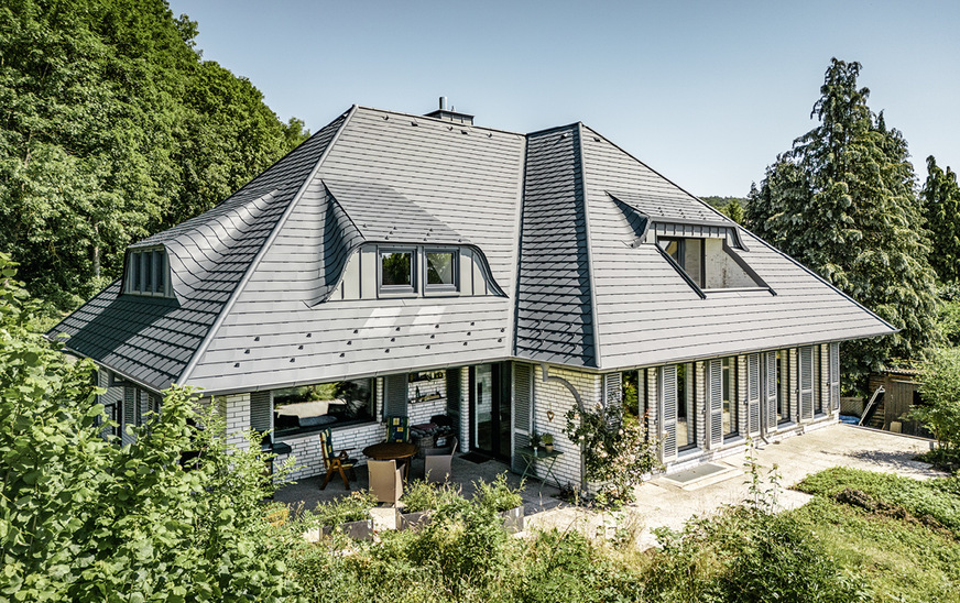 Die segmentiert ausgeführte Verblendung leitet Niederschlagswasser vom Gaubendach seitlich am Dachausschnitt vorbei – auch am Balkon