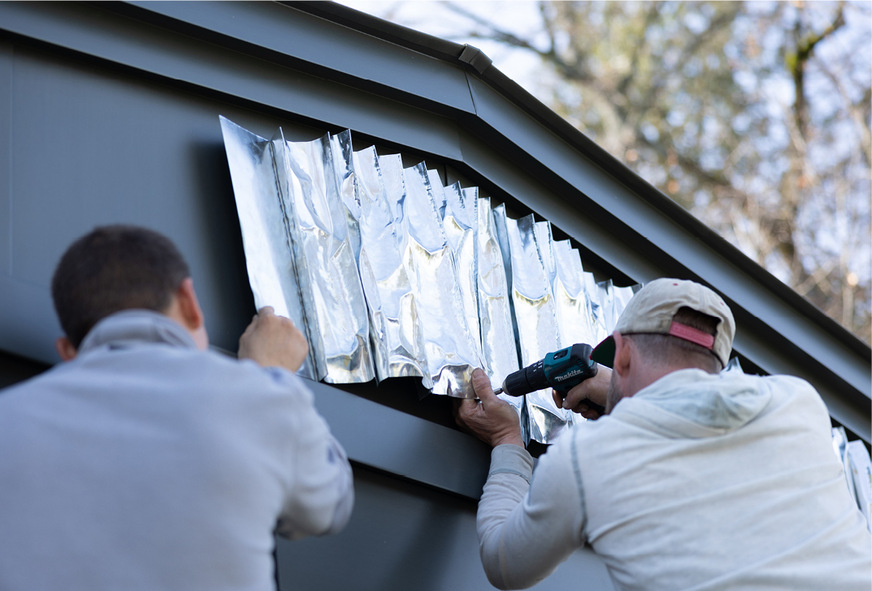 &nbsp;Fachleute der Blechnerei Mai bei der Montage bildhauerisch gearbeiteter Metalldreiecke