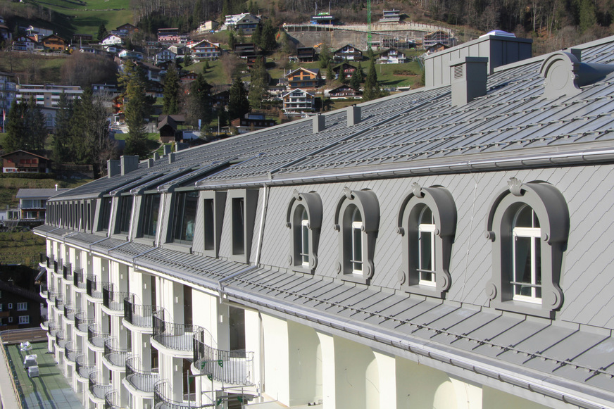 Der Übergang zwischen dem historischen Teil und der Erweiterung ist durch die Gestaltung der Lukarnen sowie die Glas-Einbauten erkennbar