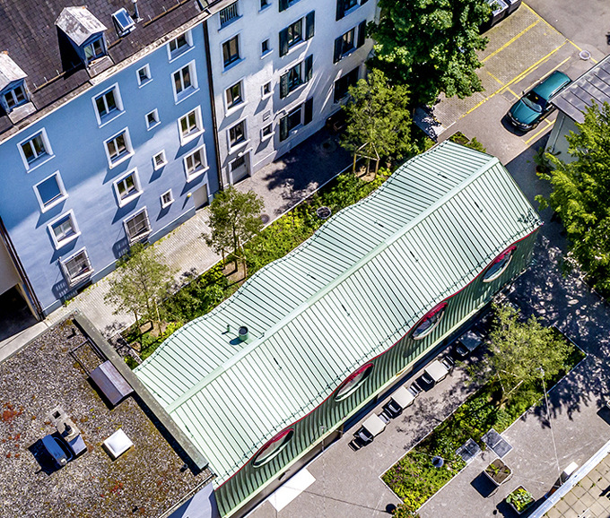 Aus der Vogelperspektive erscheint das wellenförmige Kupferdach über­raschend homogen und strukturiert