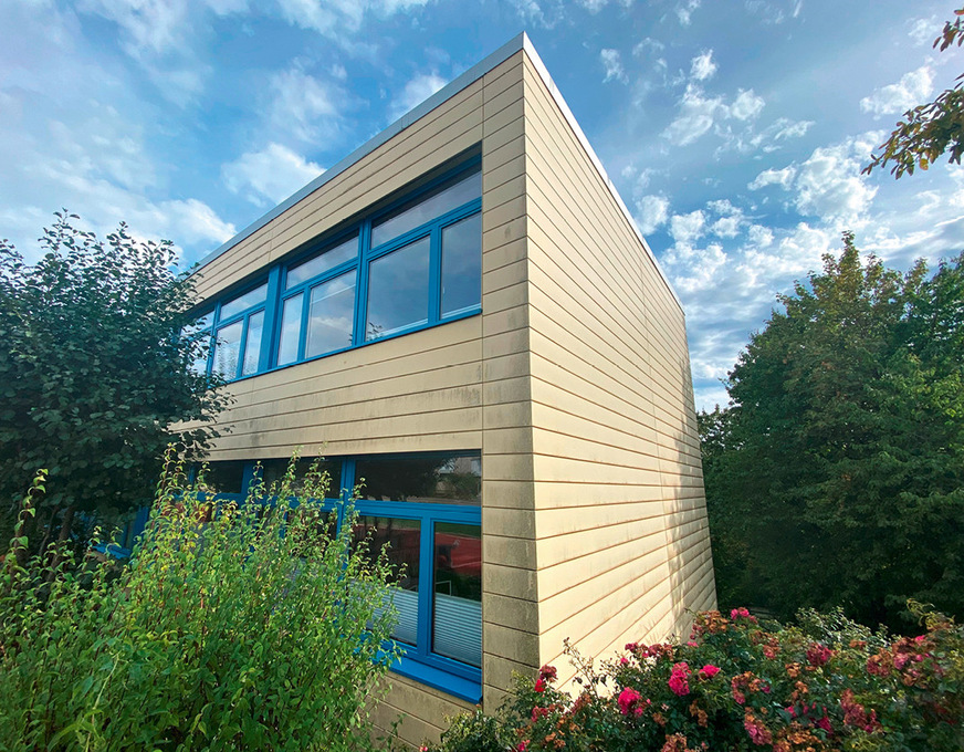 Eine um die Jahrtausendwende errichtete Paneelfassade aus gekantetem und farbbeschichtetem Aluminium