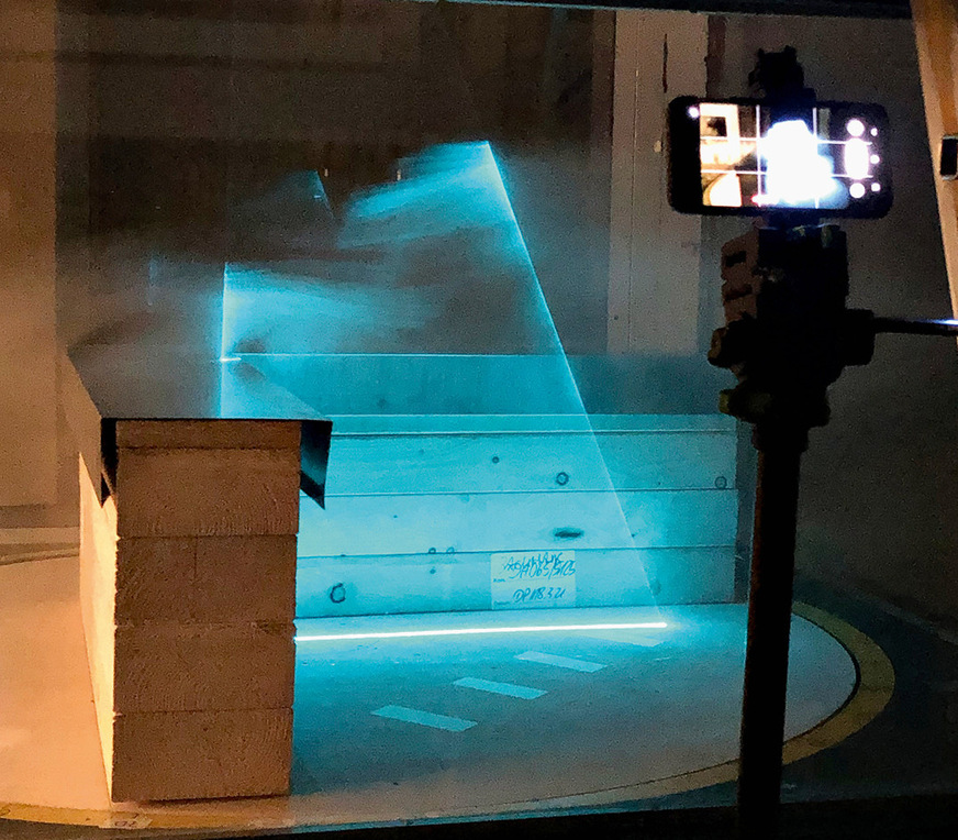 Der Prüfkörper steht auf einem Drehteller. ­Spezielle&nbsp;Leuchtkörper und das einblasen von Kunstrauch machen die Windströmung sichtbar