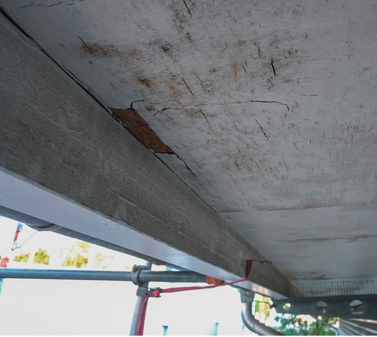 Feuchtigkeitsspuren und Schimmelbefall an der Unterseite des Dachvorsprungs