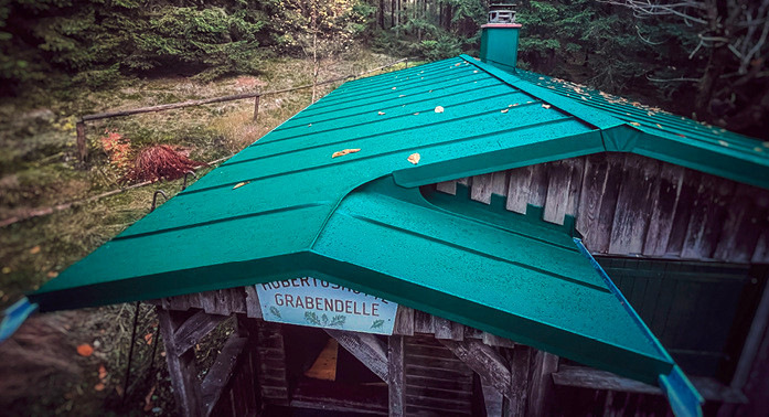 Die Hubertushütte im Thüringer Wald fügt sich mit ihrem moosgrünen Aluminiumdach gut in die Landschaft ein