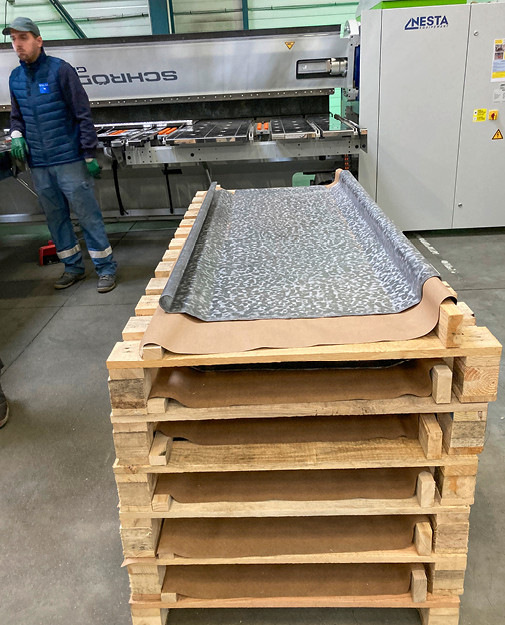 Zum Versand vorbereitete Bleitafeln. Im Hintergrund die motorische Schwenkbiegemaschine PowerBend Professional mit drehbarer Oberwange in der Nutzlänge 3200 mm x 3,0 mm Blechstärke von Schröder