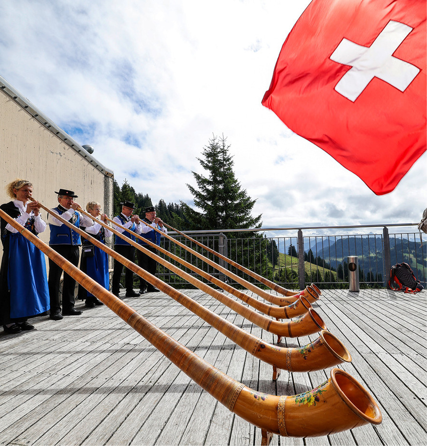 Alphornbläser und ein Fahnenschwinger begrüßen die Teilnehmenden