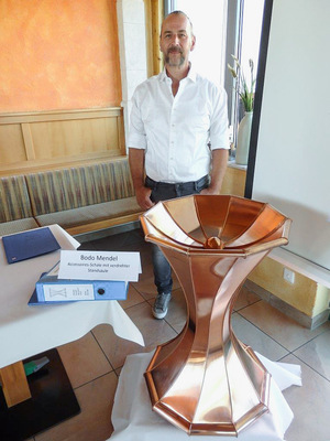 Der Klassenälteste, Bodo Mendel (50+), zeigt seine Accessoires-Scala mit perfekter, verdrehter Säule