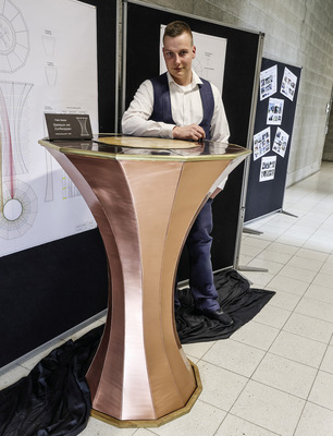 Felix Mader an seinem Stehtisch mit Zunftwappen