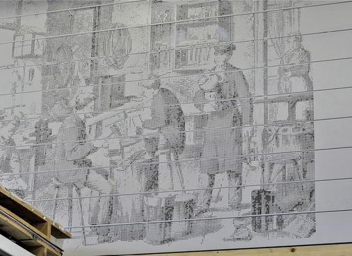 Tradition trifft auf Moderne: Diese Gökelmann-Lochbildfassade zeigt einen Blick in eine alte Klempnerwerkstatt - © Bild: BAUMETALL
