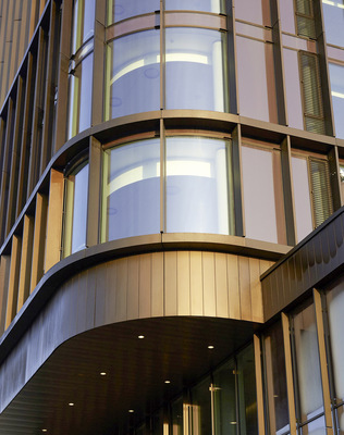 Gebogene Glasfassaden, senkrecht angeordnete Kupferpaneele und -lisenen ... 