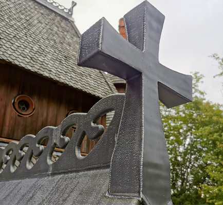 Die wellenförmigen Firstreiter verbinden das Dach mit dem aufgesetzten Schmuckkreuz - © Bild: M.Weiß
