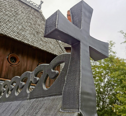 Die wellenförmigen Firstreiter verbinden das Dach mit dem aufgesetzten Schmuckkreuz