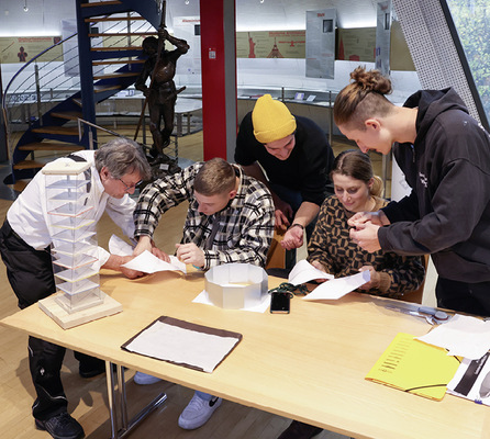 Gruppenarbeit: Teilnehmer fügen aus Papier hergestellte Abwicklungen zusammen - © Bild: BAUMETALL
