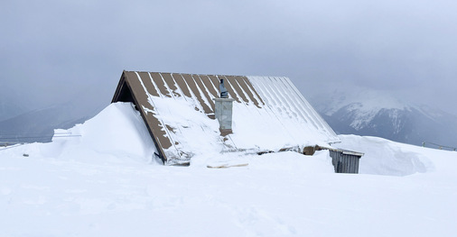    Vom Winterraum schaut nur noch das Dach aus dem Schnee