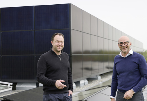 Die „Pro+“-Geschäftsführer Michael Jung und Ingo Gramm vor einer mit PV-Modulen bekleideten „Pro+“-Fassade