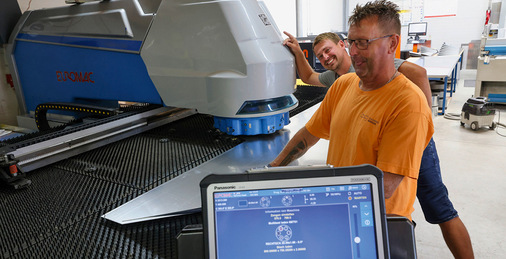 Rudolf Nowak und Michael Lieb an der mit „Zukunftsklempner“-Aufkleber versehenen Euromac-Stanze von Gogolin