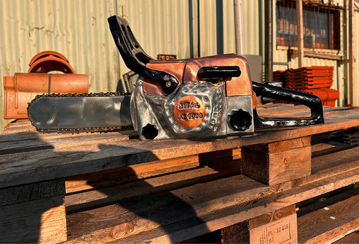 Die Skulptur einer Kettensäge besteht aus Holz, Kupfer und Zink