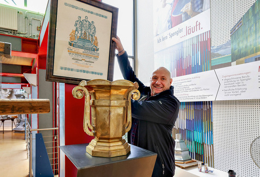 „Necko“ D. Neckermann präsentiert den historischen Pokal samt Meisterbrief