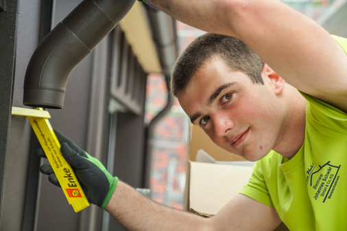 Raphael Wehrle bei der Montage eines Regenrohrs