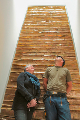 Erfolgreiche Installation: ManuG und Jonas Wicke vor stockwerk­übergreifendem Messingfries im Hamburger Alsterhaus. Ausführung: Tides, 4500 x 1600 x 80 cm