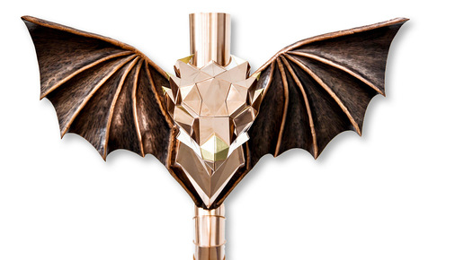 Drachenkopf mit getriebenen ­Flügeln an ­konischem Gliederbogen