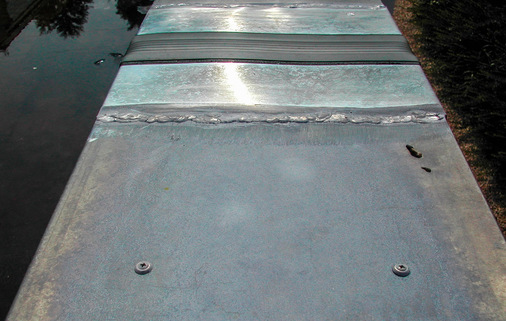 Dieser Bewegungsausgleicher an einer Dachrandabdeckung ist sinnlos: Die direkte Schraubbefestigung der Abdeckung verhindert jede Dehnungs­bewegung und ist zudem unfachmännisch