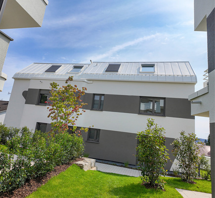 Weiße Aluminiumelemente verschmelzen mit der Fassade