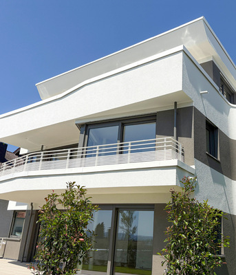 Dachrand- und Attikaprofile schmiegen sich an die geschwungene Bauform an