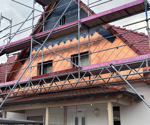 Ein Giebel während der Montage der mit Klarlack ­beschichteten Kupferrauten. Die transparente Schutz­folie auf Rauten und Profilen wurde nach der Fertig­stellung entfernt