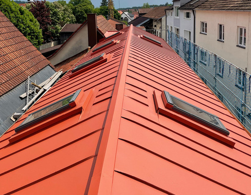 Farbbeschichtetes Aluminium von Prefa für ein Satteldach mit zahlreichen Dachfenstern