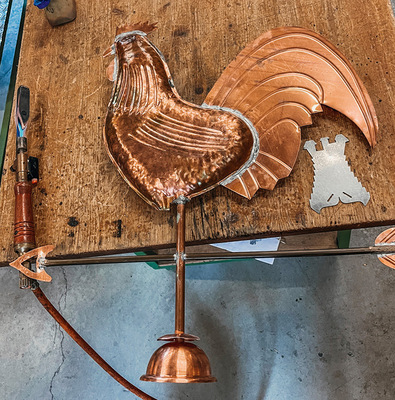 Aufgesetzt: Der fertige Hahn wird auf der Windrose montiert