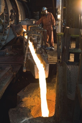 Kupfer fließt mit Temperaturen um circa 1000ºC aus dem Schmelzofen.