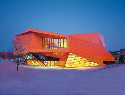 Ein Diamant aus Aluminium — die futuristische Gebäudehülle des Agora-Theaters im niederländischen Lelystad besteht aus Glas und Aluminium. Sie wechselt je nach Blickwinkel und Lichteinfall ihren Farbton. Verstärkt wird dieser Effekt durch die spezielle Aluminiumfassade. Corus Bausysteme verarbeitete bandbeschichtetes Aluminium von Reynolux Building der Firma Alcoa Architectural Products zu einem besonderen Kalzip-Profil. Außerdem kamen Wand-, Fenster- und Türprofile des Alcoa-Tochterunternehmens Kawneer zum Einsatz. Ausführung: Hafkon BV, Zaltbommel (NL) Architektur: Caroline Bos, Bernd van Berkel, UNStudio, AmsterdamMaterial: Kalzip-Profile aus Reynolux Building Aluminium in orangefarbenen Abstufungen