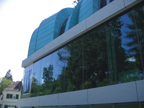 Spiegelungen in den Glasfronten, grüne Bogendächer und Ginkgoblatt-Abdrücke in den Betonfertigteilen verschmelzen mit der Natur zu einer Einheit