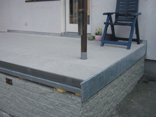 Nach 4 Tagen war die Enkopur—Abdichtung trotz schlechter Wetterlage ausgehärtet, so dass ein handelsübliches Schutzvlies aufgelegt werden konnte. Es folgte das Aufbringen des Splittbetts sowie die Verlegung der Waschbetonplatten
