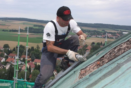 <p>Spenglergeselle Ulrich Seitz beim Härtetest. Das dräcounterstützte „Entkleiden“ der kupfernen Kuppel fand er ausgesprochen sexy</p> - © Dräco / Heinzlmeier