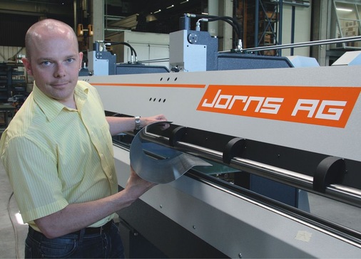 Reto Staeger führt die neue Jorns-Rinnenmaschine RM 150 vor. Auf der mit drei synchron angetriebenen Walzen ausgestatteten Anlage können zahlreiche gebogene Profilformen hergestellt werden
