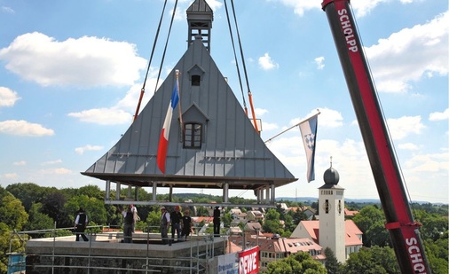 Feierlich wird der neue Turmhelm aufgesetzt