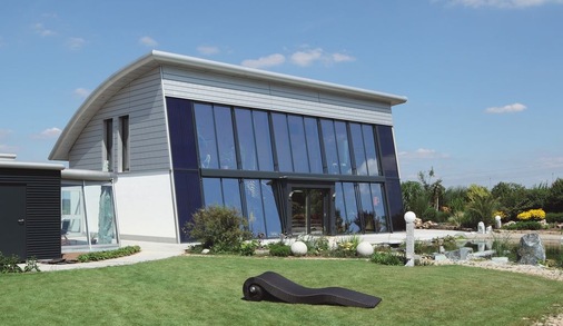 Die Südfassade wird von großen Glasflächen und Solarkollektoren dominiert
