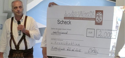 Auf der Preisverleihung überreicht der Vorstand der freien Spenglermeistervereinigung Bayern (SMV) einen 2000-Euro-Scheck für die Kranichaktion. Der Vorstandsvorsitzende Werner Fünfer lobt dabei die Bemühungen von So Iwamoto und seinem Kranich-Team